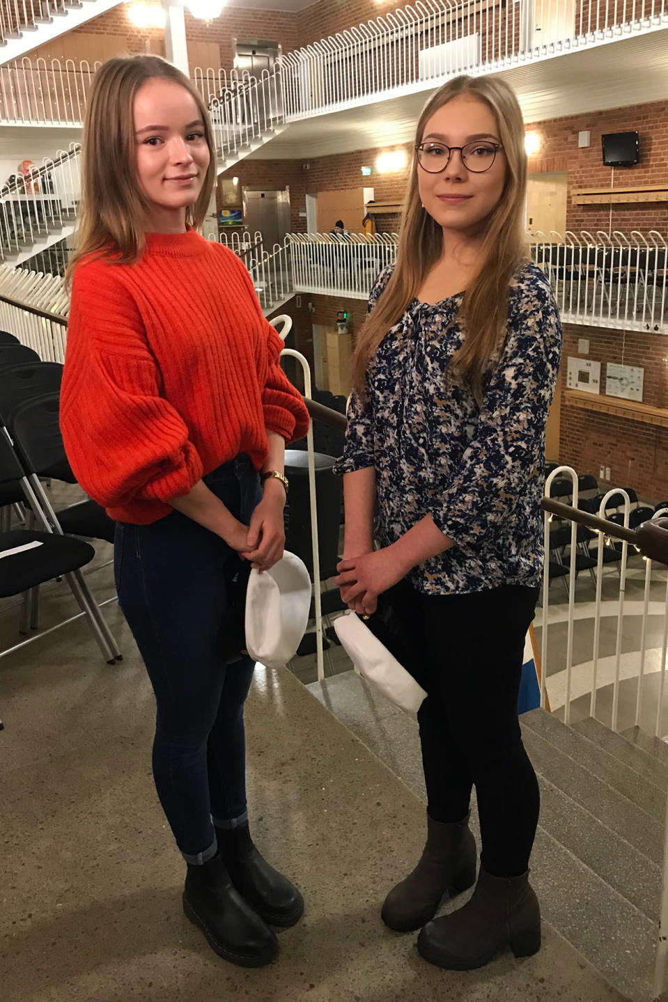 Ada Rantala (vas) ja Emilia Tammilehto valkolakit kädessä Lyseonpuiston lukion juhlasalissa.
