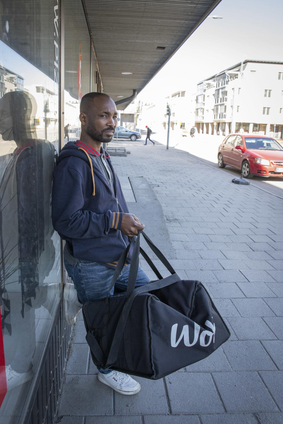 Muhammed Musah seisoon kadulla Woltin ruoankuljetuslaatikko kädessään.