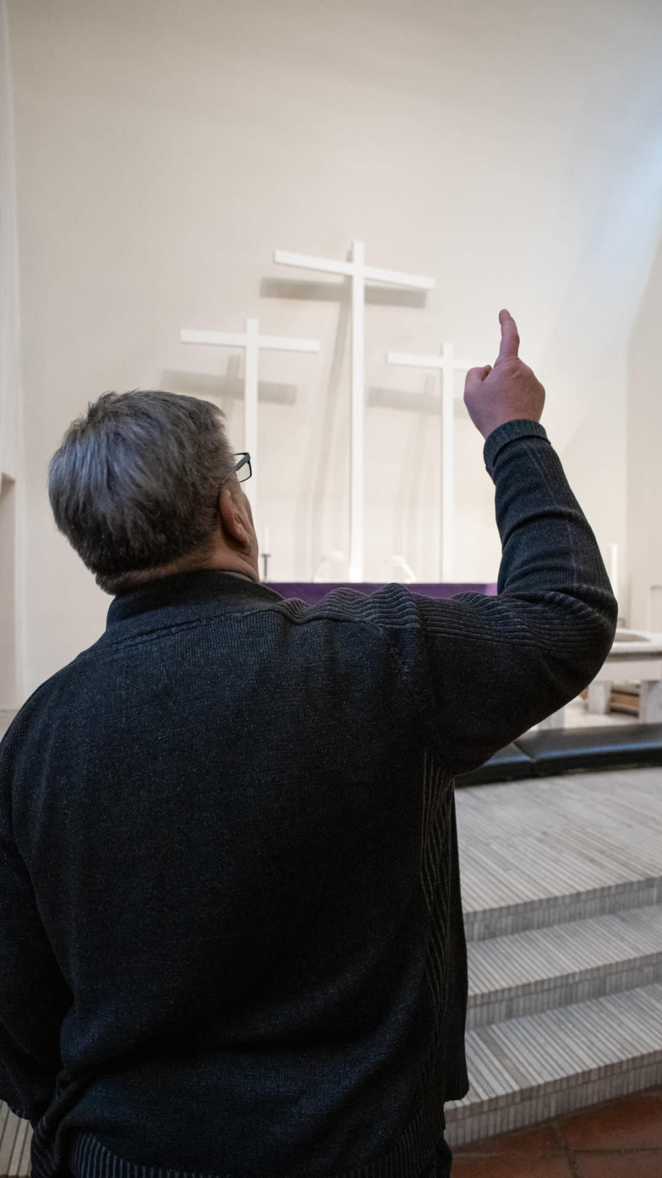 Kiinteistöpäällikkö Jari Nousiainen osoittaa Kolmen ristin kirkon alttaria, johon aamuauringon säteet osuvat.