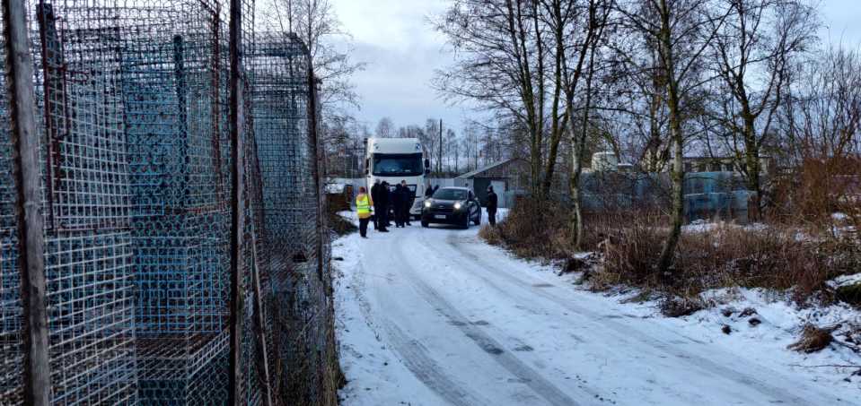 Turkiseläinten häkkejä, taustalla eläinkuljetusrekka