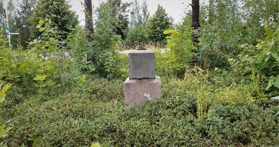 Alkuperäisen leirikirkon muistokivi pusikon keskellä