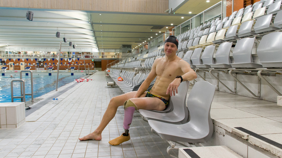 Paratriathlonisti Jussi Lotvonen istuu Raksilan uimahallin katsomossa.