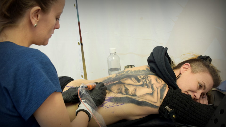 Säde Sonck tatuoi Jenni Ahtiaisen selkää