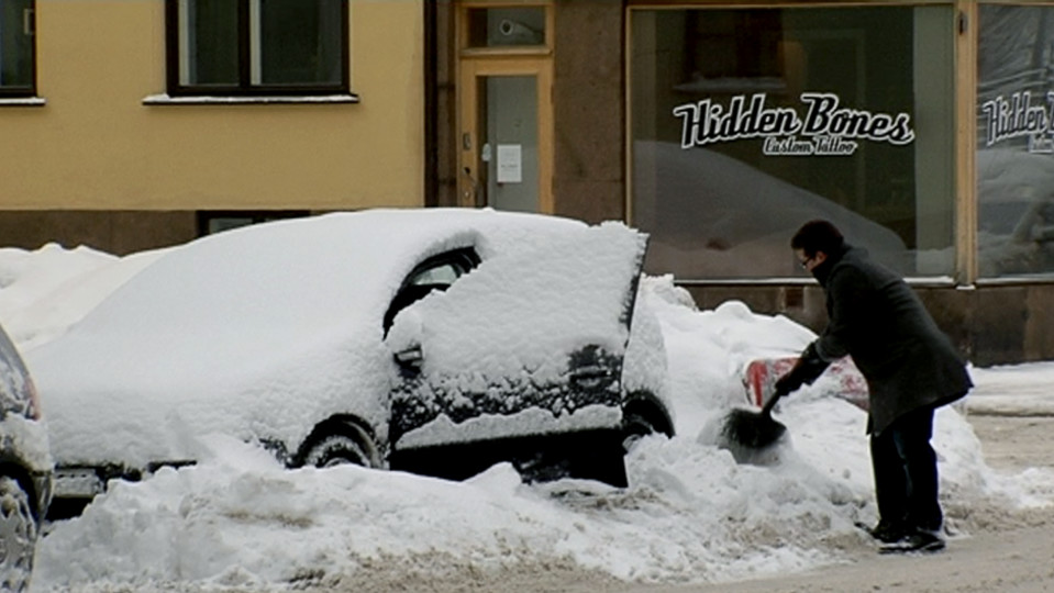 Mies kaivaa autoa kinoksesta