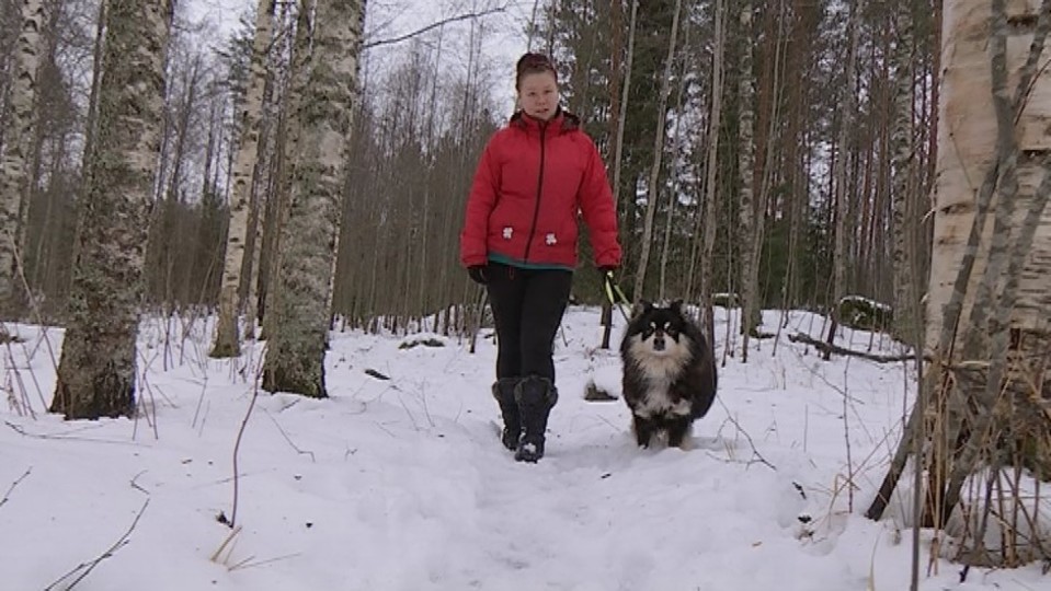 Minna Matilainen ulkoiluttaa koiraa.