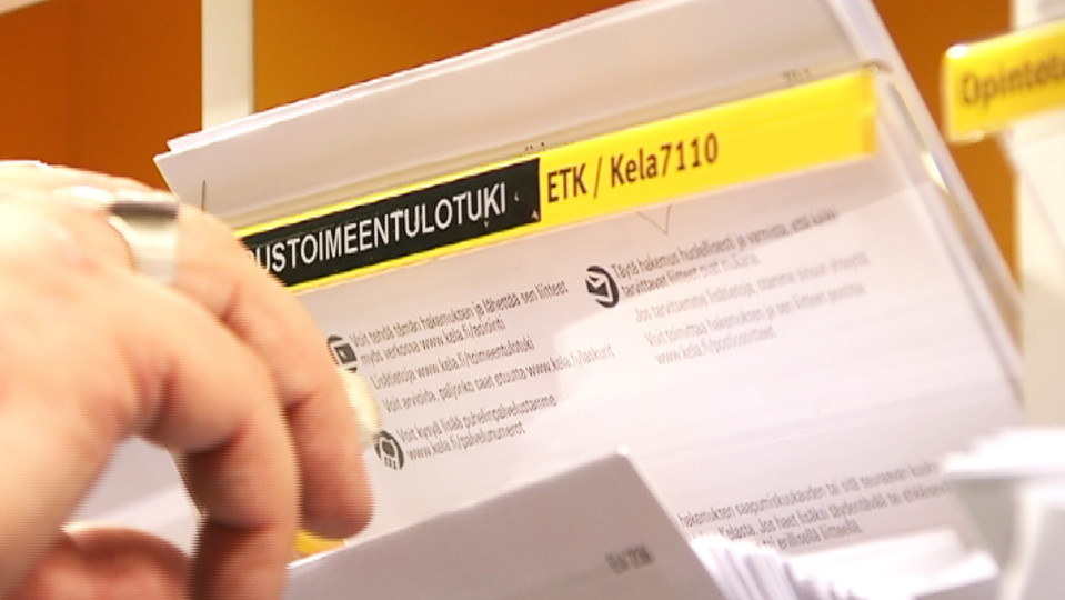 Kelan toimeentulotukihakemuslomakkeita telineessä.