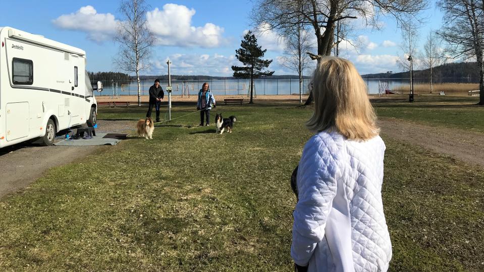Messilän leirintäalue Camping Messilä keväällä ja kaksi matkailjaa matkailuauton vieressä