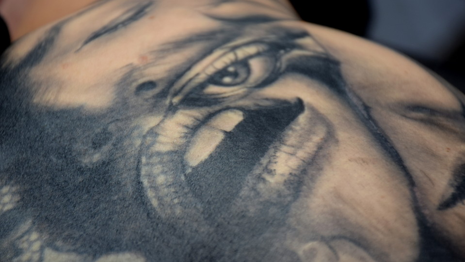 Jenni Ahtiaisen selän tatuoinnissa kasvoja, suu, silmä