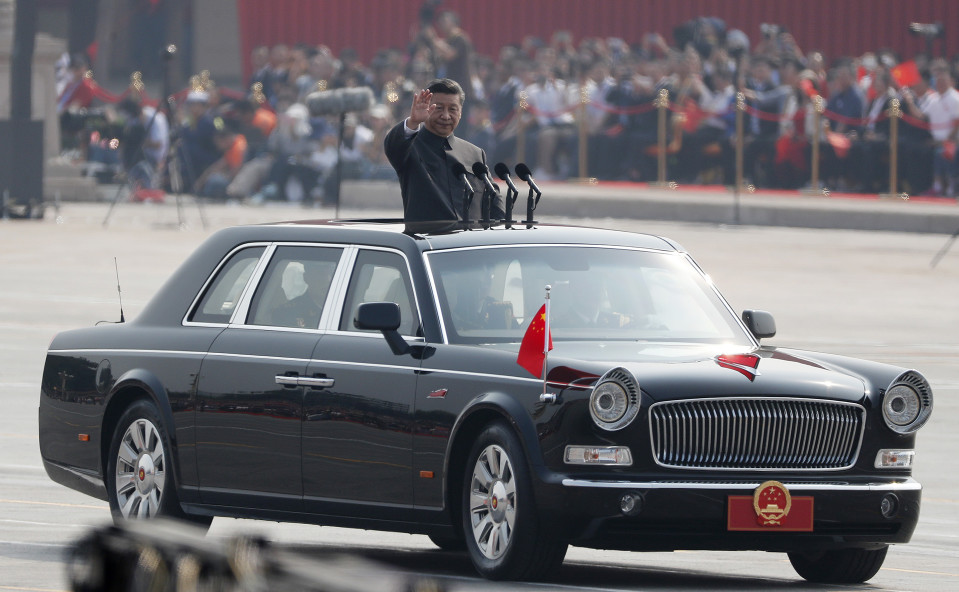 Kiinan presidentti Xi Jinping vilkuttaa autosta