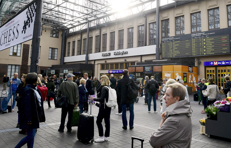 Ihmisiä seisoskelee Helsingin päärautatieasemalla.