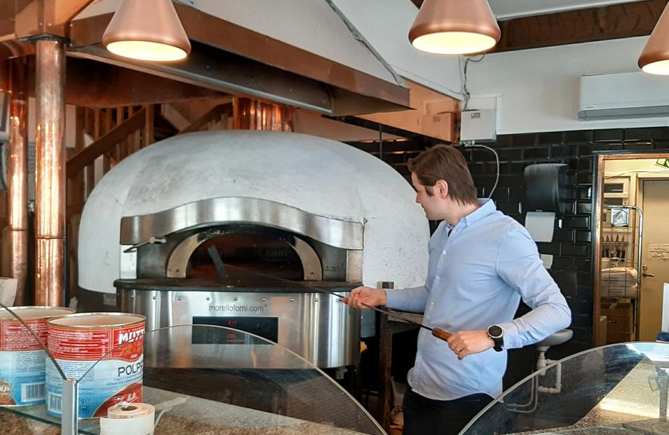 Henrik Riipinen sytyttää Pizzeria Rukan uunia.