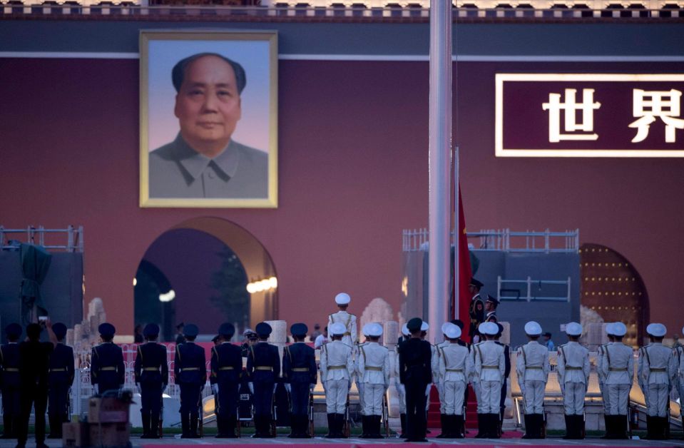 Kiinan armeijan kunniavartiosto seisoi asennossa Mao Zedongin kuvan edessä Taivaallisen rauhan portilla Pekingissä, kun Kiinan lippua laskettiin salosta maanantai-iltana.