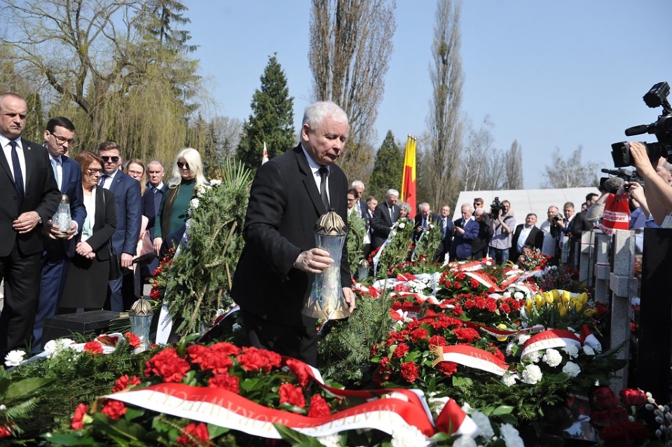 Kaczyński seisoo seppeleiden keskellä hautausmaalla.