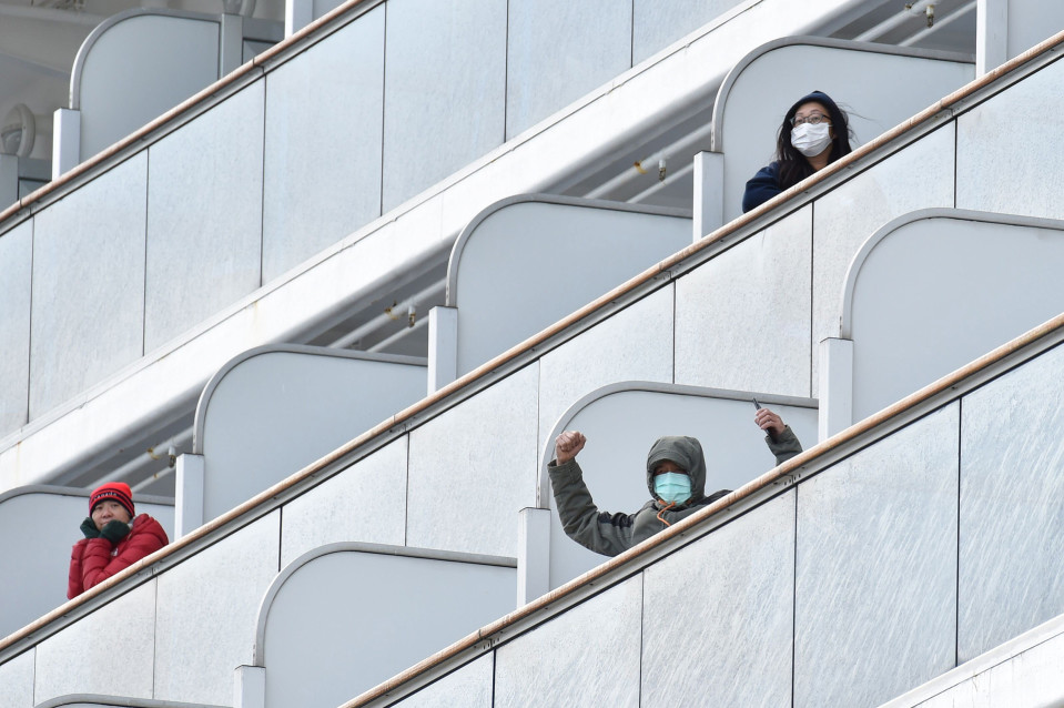 Diamond Princess -aluksella karanteenissa olevat matkustajat vilkuttivat medialle 6. helmikuuta.