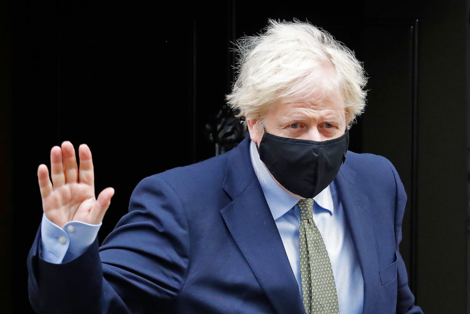 Boris Johnson poistumassa Lontoon Downing Streetiltä maski kasvoillaan.