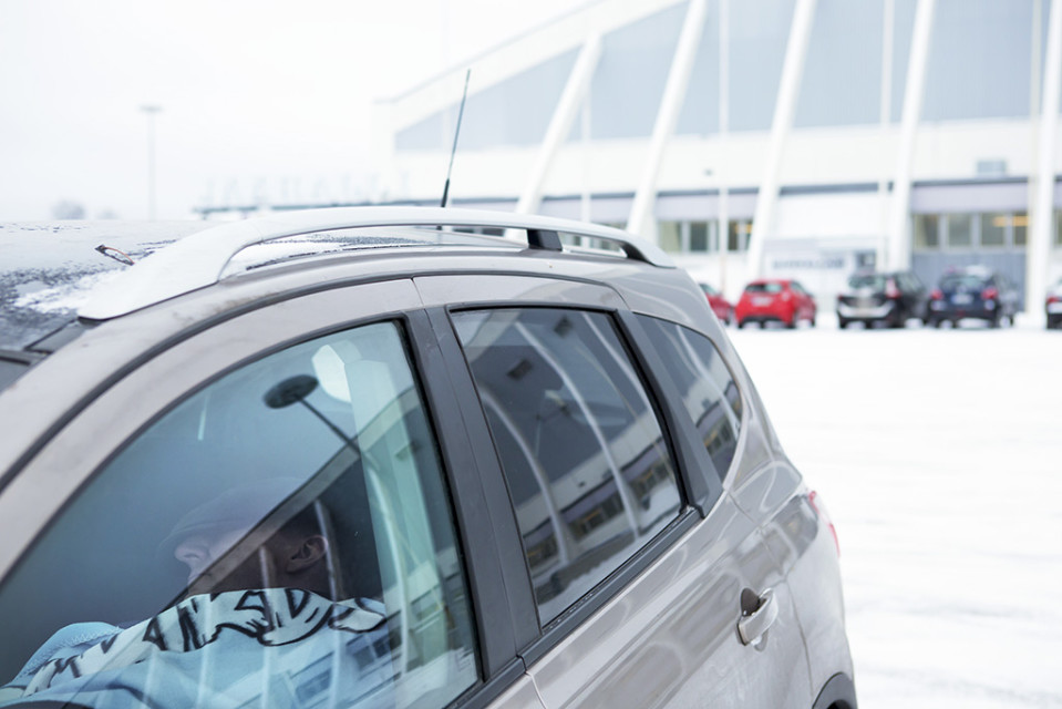 mies nukkuu autossa parkkipaikalla