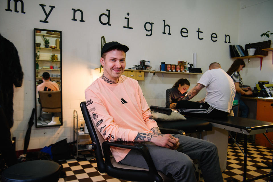 mies tuolissa tatuointistudiossa