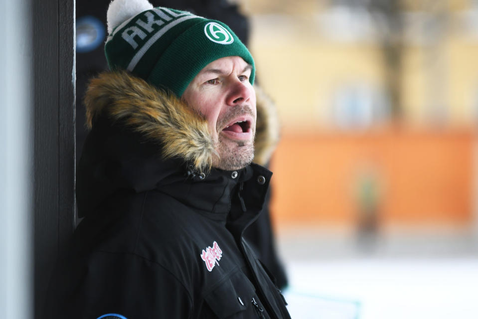 Akilles bandytränare Jari Hyttinen är iklädd Akillesmössa och ropar instruktioner åt sina spelare.