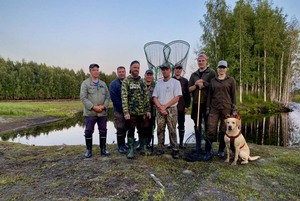 ihmisiä kosteikon reunalla