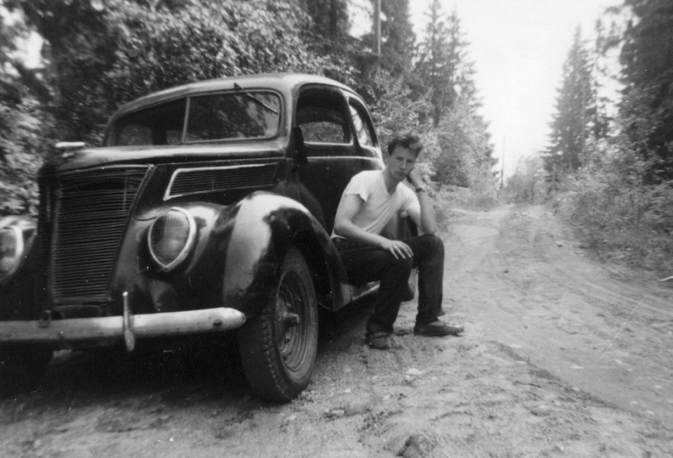 Mies istuu vanhan auton astinlaudalla vuonna 1958