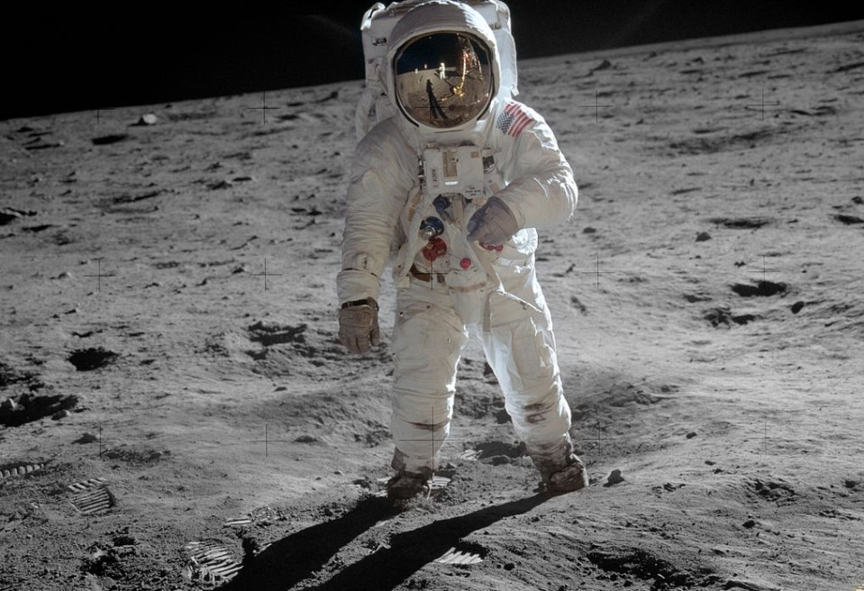 Astronautti kävele Kuun pinnalla. Pölyssä näkyy jalanjälkiä.