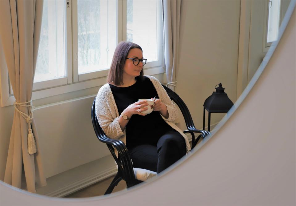 Katri Pentti juo teetä tuolissa.