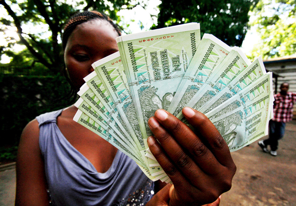 Zimbabwelaisnainen pitelee tukkua kymmenen biljoonan Zimbabwen dollarin seteleitä.