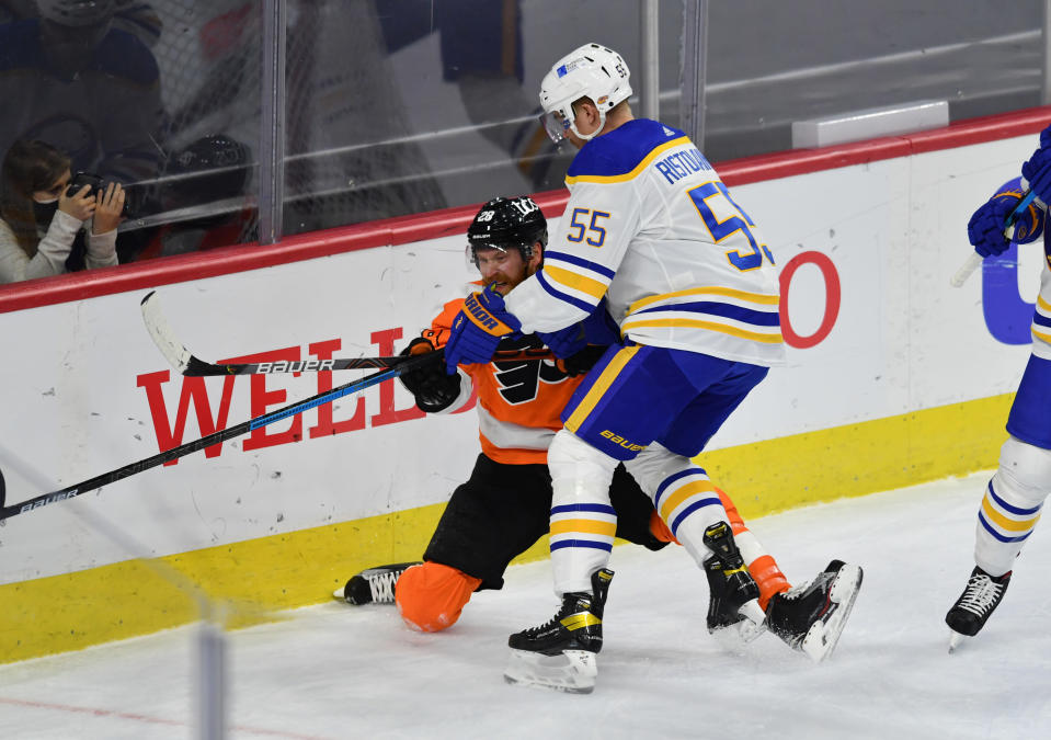 Rasmus Ristolainen taklaa Philadelphian pelaajan pleksiä vasten.