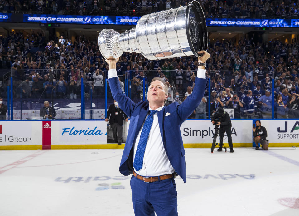 Päävalmentaja Jon Cooper nostaa Stanley Cupin ilmaan.