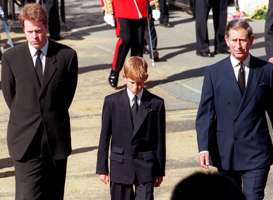 Harry kävelee miesten keskellä. Kaikki ovat pukeutuneet mustiin.