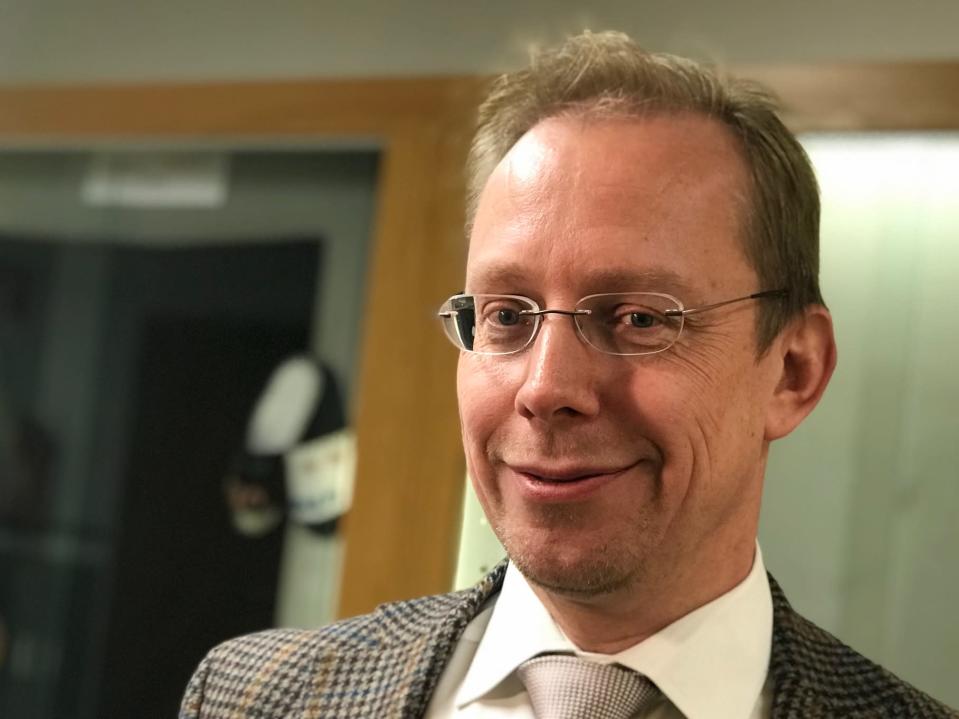 Rehtori katsoo kameraan lähikuvassa