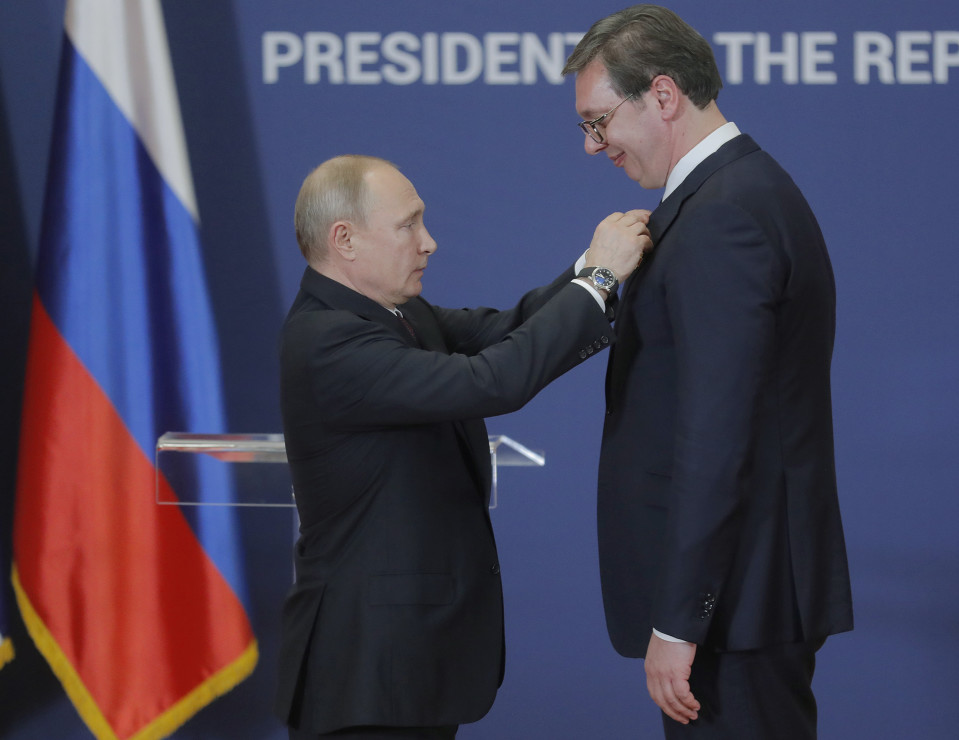 Vladimir Putin kiinnittää kunniamerkin Alexandar Vucicin rintaan.