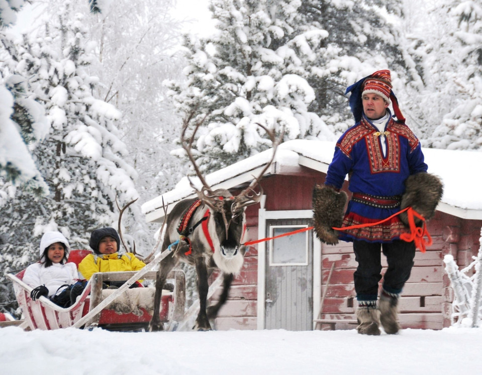 Kiinalaisturisteja poroajelulla Rovaniemellä.