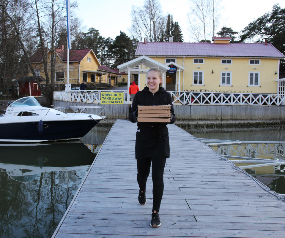 Tarjoilija Lotta Raitanen tuo pizzoja laiturille Merimaskussa.