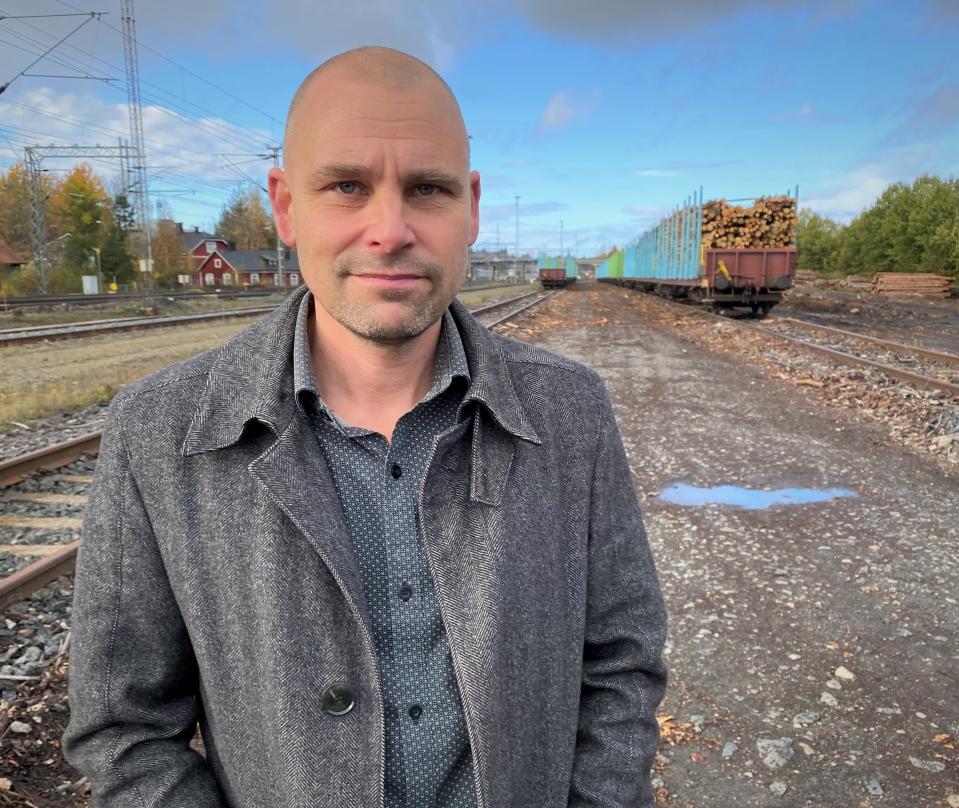 Mies seioo ratapihalla, takana pitkä juna