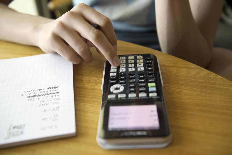 Nuori laskee matematiikan tehtäviä funktiolaskimella.
