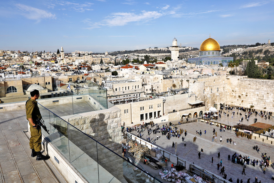 Israelilainen sotilas tarkkailee Jerusalemin vanhaakaupunkia ja Itkumuuria kattotasanteelta. Alueella sijaitsevat pyhät paikat niin muslimeille kuin juutalaisille.