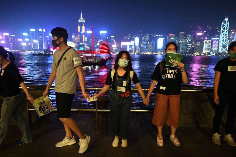 Mielenosoittajat muodostivat ihmisketjun Hongkongin satama-alueella maanantai-iltana.