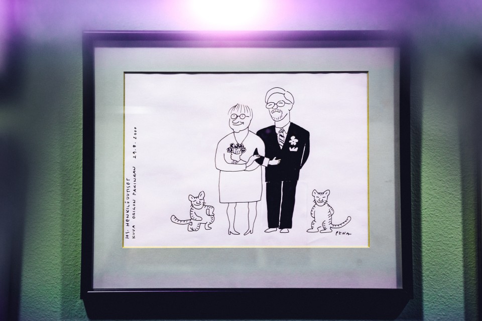 Kuva piirroksesta, jossa seisovat hääasuissaan Tarja Halonen ja Pentti Arajärvi, vieressä kaksi kissaa.