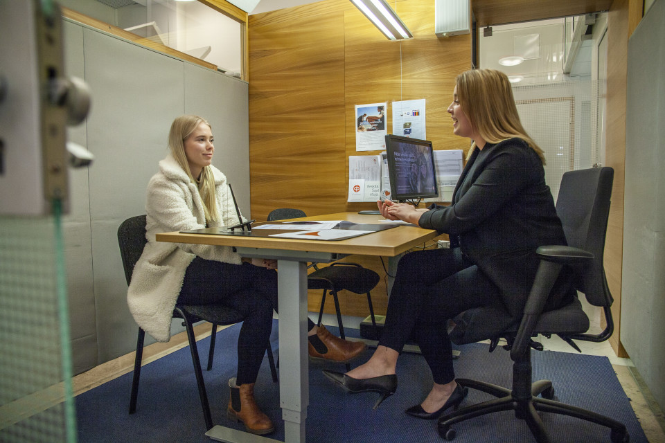 Pohjois-Savon Osuuspankin asiakasneuvoja Julia Jerkku keskustelee raha-asioista Kuopiolaisen nuoren Olivia Honkosen kanssa.