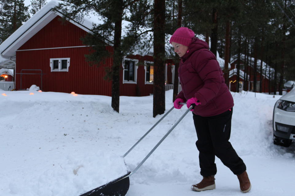 Inarilainen Eevi Korva kolaa pihaa ja toivoo että lumisateissa tulisi jo pieni tauko.
