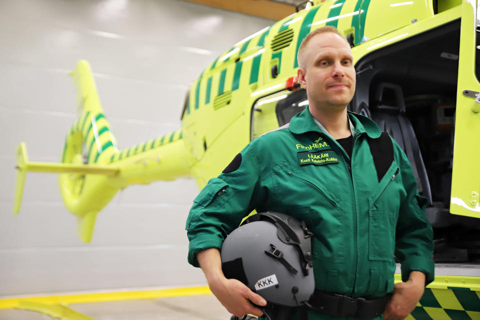 Mies poseeraa lääkärihelikopterin edessä.