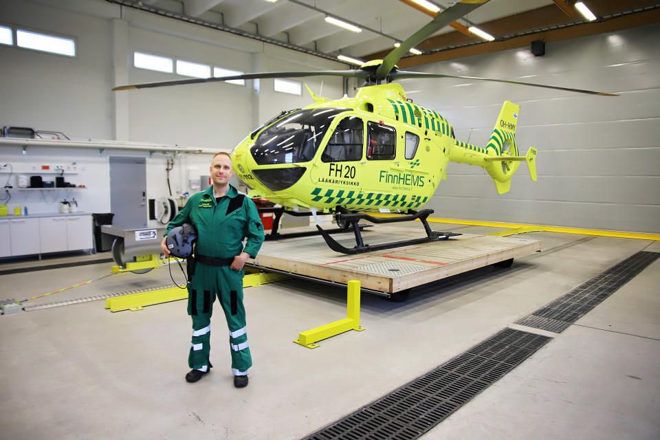 Mies poseeraa lääkärihelikopterin edessä.