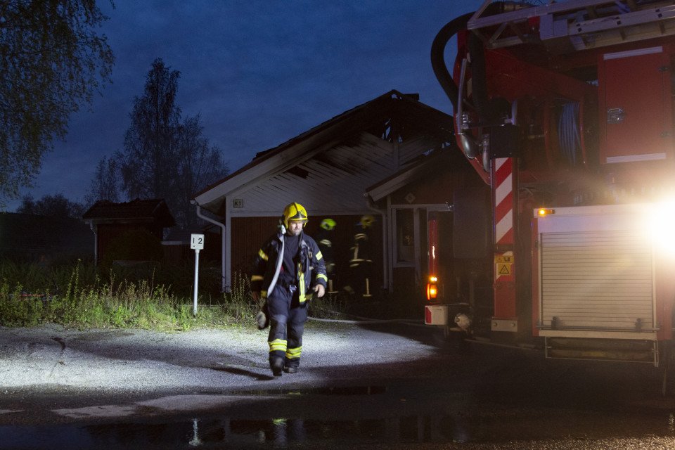 Palomies palosta kärsineen talon edustalla