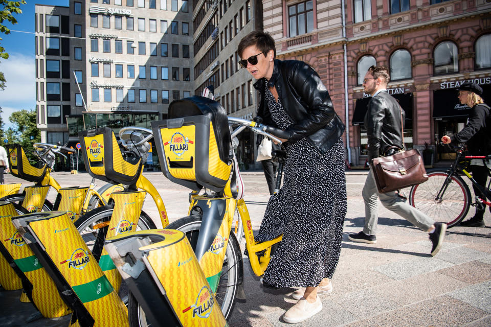Nainen palauttamassa kaupunkipyörää Helsingissä.