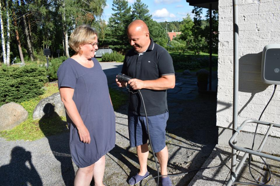 Kirsi ja Jari Nuutinen tutkivat sähköauton latauspistoketta.