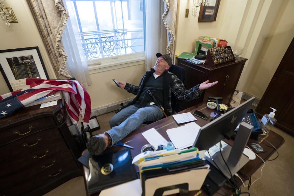 Donald Trumpin kannattaja poseerasi edustajainhuoneen puhemies, demokraatti Nancy Pelosin työpöydän ääressä.