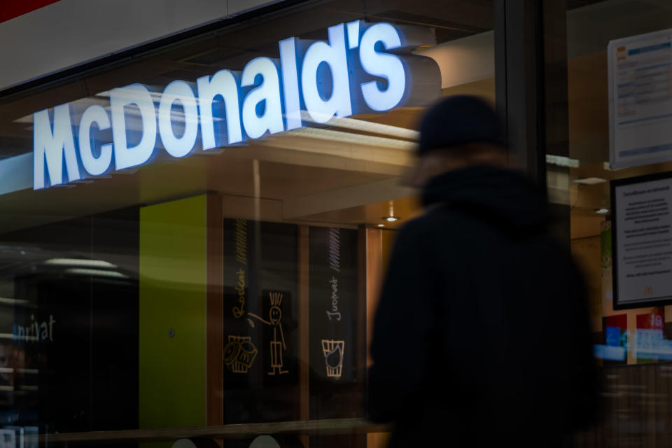 Nuori kävelee McDonalds's mainoskyltin alta.