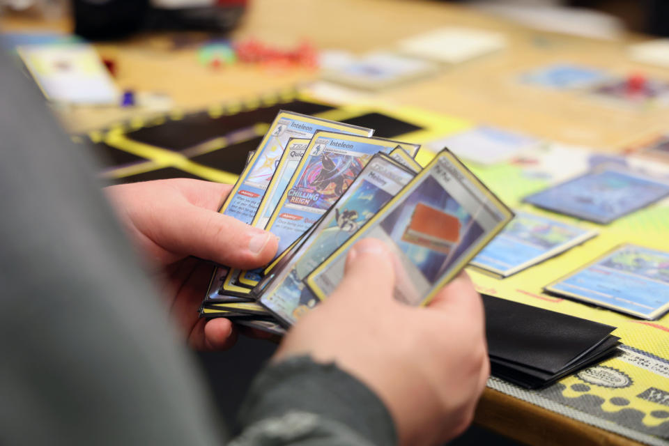Pokémon-korttipelin pelaamista pöydän ääressä.
