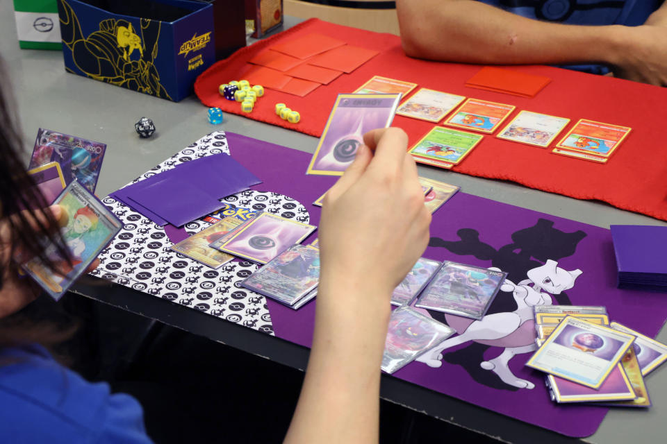 Pokémon-korttipelin pelaamista pöydän ääressä.